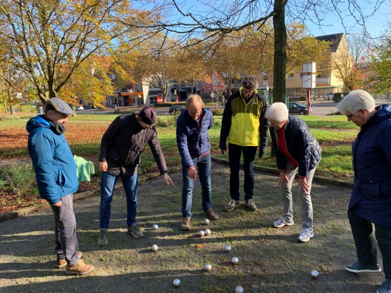 Personen spielen Boule auf einer Boule-Fläche in Holzhausen bei sonnigem