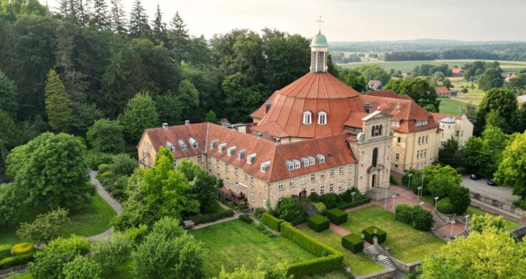 Haus Ohrbeck, das Kloster in Holzhausen, umgeben von grünen Gärten und Wäldern.